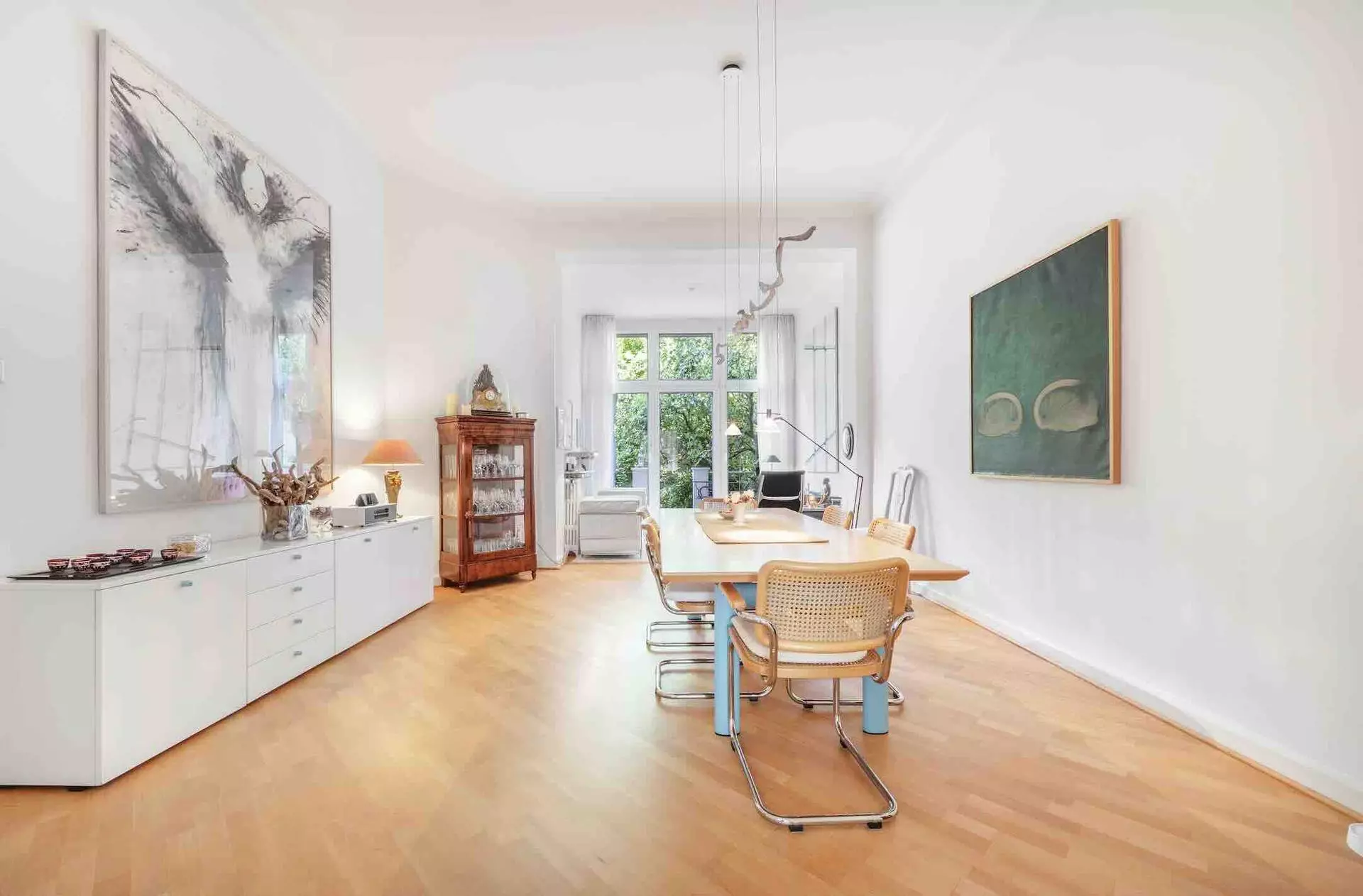 Esszimmer mit Massivholztisch und antiker Vitrine in einer Altbauwohnung